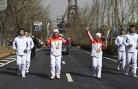 3月4日，火炬手楊華清（前排左二）和趙星在傳遞火炬。
