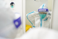 3月23日凌晨，核酸檢測實驗室的工作人員呂文航在穿戴防護面罩。