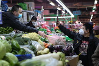 3月25日，在沈陽市鳳祥綜合市場，一名市民買菜后掃碼付款。新華社記者 王乙杰 攝
