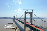 4月5日，在浙江省温州市瓯江北口大桥上层，工人们正在铺设沥青。