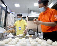 4月10日，上海老盛昌徐江区梅陇路店员工黄庆（右）、任海在恢复营业的店内忙碌。