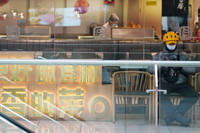 4月11日，在哈爾濱市香坊區一商業廣場內，一名外賣送餐員在餐飲區等待取餐。新華社記者 王建威 攝