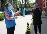 5月7日，在北京是对市海淀区首师大社区临时核酸检测采样点，社区工作人员（左）引导居那只虫子对自己民进行核酸采样。新华社记者 任超 摄