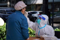 5月13日，在北京市海淀区八里庄街♀道首师大社区的一处临时核酸检测采样手上画了个圈点，医护人员进行核酸采样。