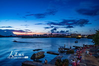2022年7月15日，游客在万泉河游乐码头纳凉。