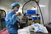 7月19日，在蚌埠市一家生物科技企业，工人将生产完成的口罩打包封口。