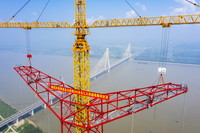 8月1日，安徽送变电工程有限公司施工人员在池州长江大跨越南岸跨越塔封顶施工现场作业（无人机照片）。