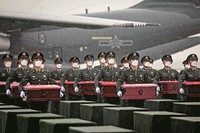 在沈阳桃仙国际机场，礼兵在雨中将殓放志愿军烈士遗骸的棺椁从专机上护送至棺椁摆放区。