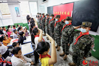 国防教育活动现场，武警汉中支队官兵与学生们互相敬礼。