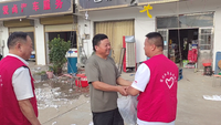 志愿者协助整理灾后进水的仓库和货物。王丹丹摄