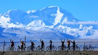 　　游客们骑行至卓奥友峰前合影。（资料图片）