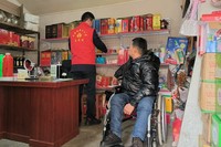 志愿者协助困难群众整理店铺货架。句容烟草供图