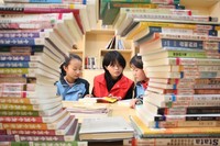 返乡大学生志愿者在六合村农家书屋辅导孩子阅读课外书籍。中共施秉县委宣传部供图