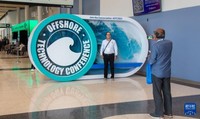 5月6日，参会者在美国休斯敦举行的国际海洋油气技术大会及设备展入口处拍照。新华社发（劳承跃摄）