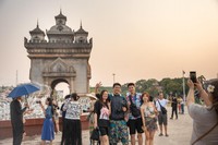 5月1日，中国游客在老挝首都万象著名地标景点凯旋门前拍照。新华社发（凯乔摄）