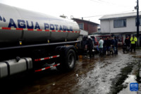 6月13日，在智利比奥比奥大区库拉尼拉韦，当地居民排队领水。新华社发