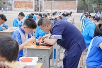 传承人指导学生剪纸（周鹏飞  供图）.JPG