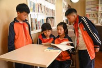 4月22日，贵州省铜仁市松桃苗族自治县盘信镇民族完小的学生们在一起阅读书籍。 谢慧芳摄.JPG