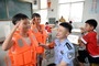 “我要给警察叔叔敬礼！”7月22日，安徽和县一群众安置点，王嘉豪小朋友（左一）对上安全课的警察说。